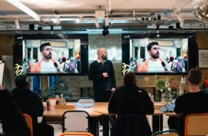 About iam icon advertising and marketing A professional leads a presentation with digital displays in a modern office environment.